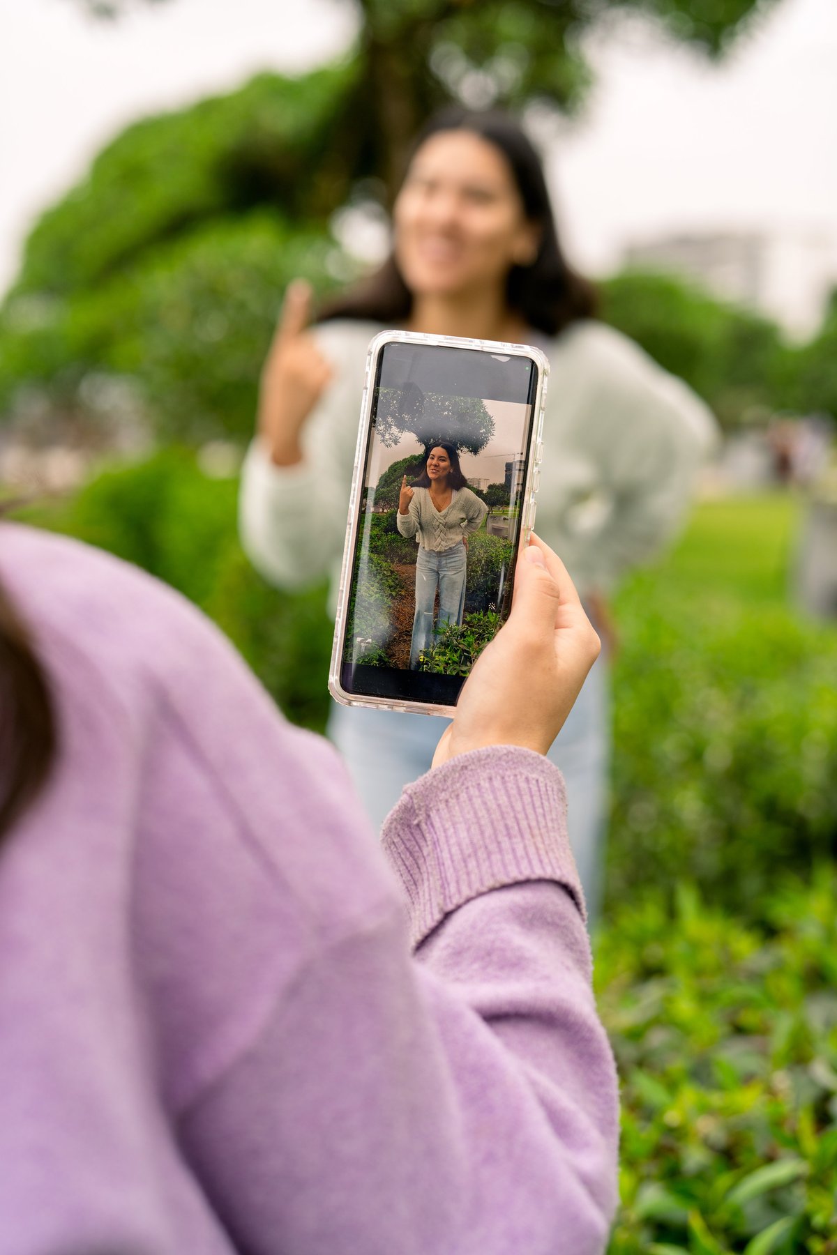 Person filming content with smartphone outdoors